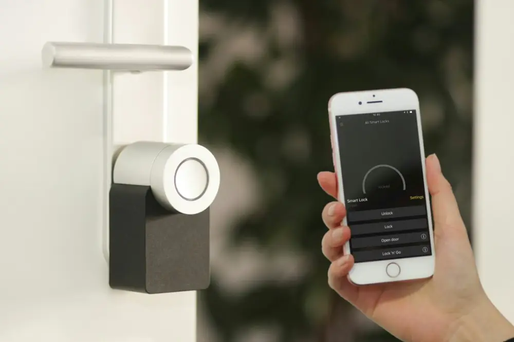 Gold Apple iPhone smartphone held at the door, illustrating modern access systems